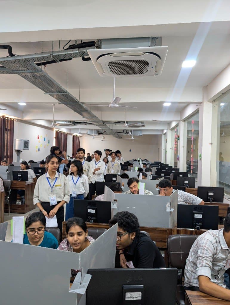 CodeLock teams working at their computers, with team numbers taped to the desk dividers.