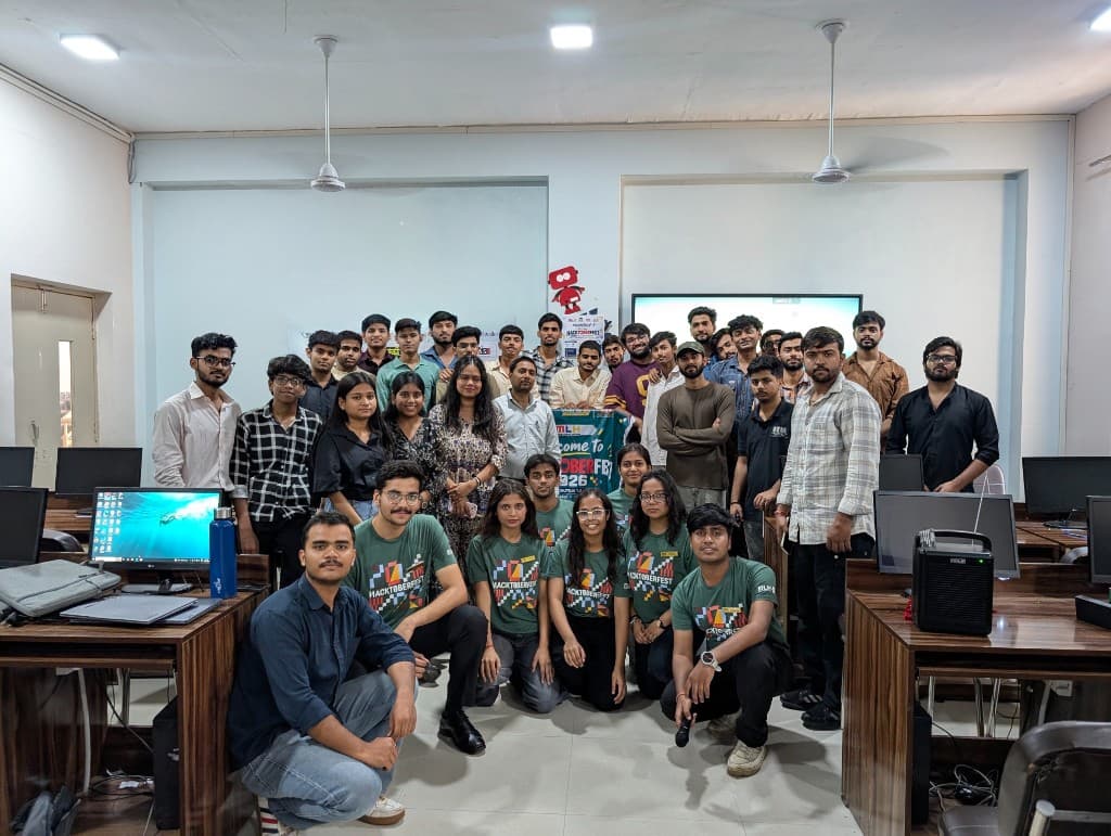 Hacktoberfest Hack Day group photo in the computer lab, with participants in green Hacktoberfest shirts kneeling in front.
