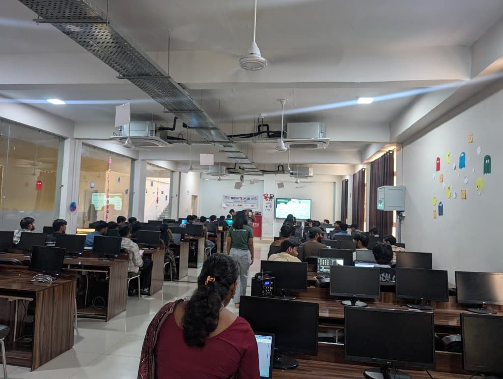 A wide view of the packed Hacktoberfest lab, with Pac-Man drawings on the right wall.